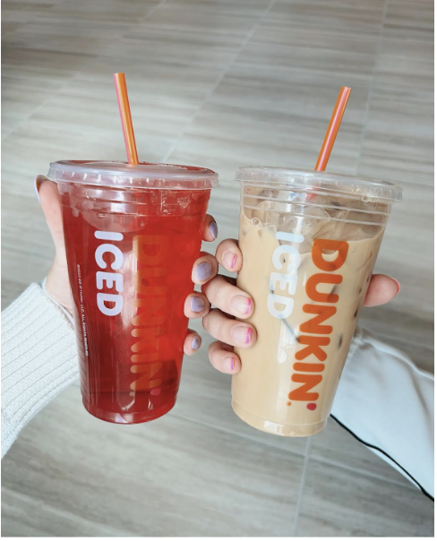 Hands holding a refresher and a coffee (